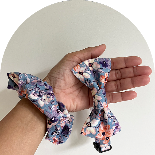 Matchande husdjursfluga och ägarens scrunchie med blommigt mönster i blått.